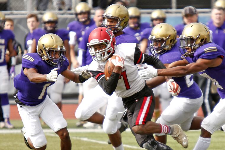 Roman Catholic defensive back Malachi Harris (left) gets a lot of help from his friends as he tries to take down Archbishop Carroll running back Dahmir Ruffin in the third quarter of a Catholic League Red Division football game Saturday, Sept. 30, 2017 at Johnston Memorial Stadium in Mount Airy. Roman went on to win, 6-0.