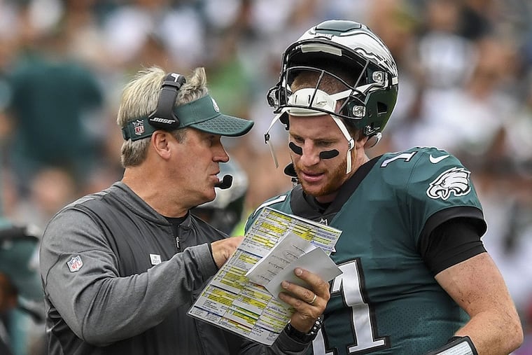 Eagles quarterback Carson Wentz and head coach Doug Pederson confer about a play against the Cardinals.