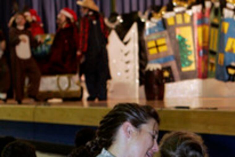 Lynette Falkenstein and her son, Andrew, 2, watch the Christmas play at Fort Dix. The base held a "Hearts Apart" holiday party for military families who have loved ones at war.