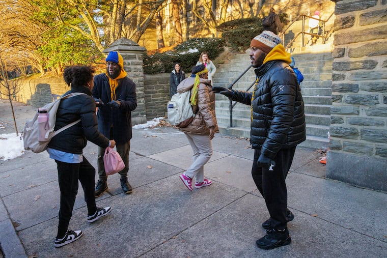 Marcus Tolbert, right, and Khayri McKinney, left, both volunteers with Jenks Dads on Duty, help students make it safely into their school building. Dads on Duty direct traffic, greet students, moderate disputes and even shovel snow when necessary daily. The group monitors arrivals and dismissals daily.