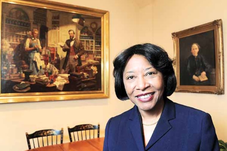 Portrait of Helen F. Giles-Gee, new president of The University of the Sciences, in her office March 21, 2013 flanked by a painting of an early apothecary and a portrait of the first female graduate of the school, Susan Hayhurst, who graduated in 1883. ( CLEM MURRAY / Staff Photographer )