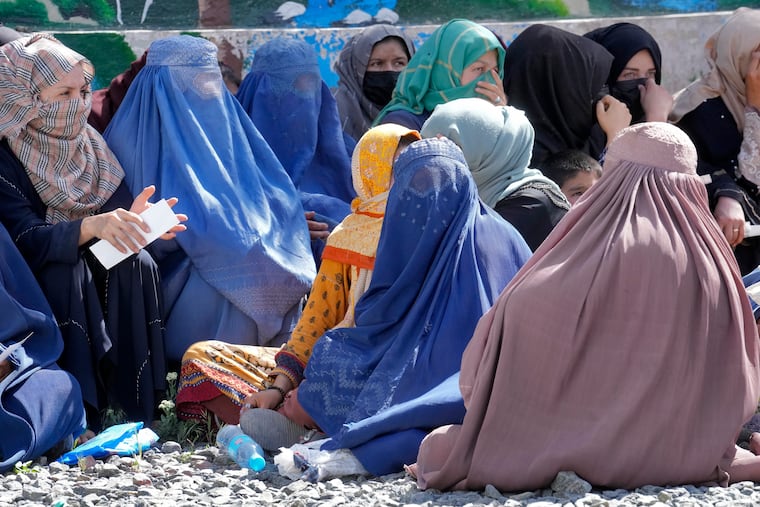 Afghan women wait to receive food rations distributed by a Saudi humanitarian aid group, in Kabul, Afghanistan, Monday, April 25, 2022. Afghanistan’s Taliban rulers on Saturday, May 7, ordered all Afghan women to wear head-to-toe clothing in public, a sharp hard-line pivot that confirmed the worst fears of rights activists and was bound to further complicate Taliban dealings with an already distrustful international community.