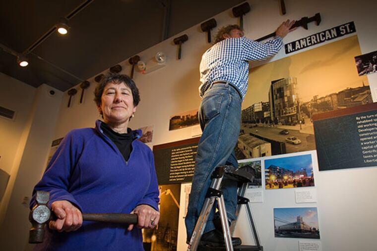 Jennifer Baker, exhibit curator for "Northern Liberties: from Worlds Workshop to Hipster Mecca and People in Between," exhibit at the Philadelphia History Museum in Philadelphia. Randy Dalton assists in hanging the exhibit in the background. ( ALEJANDRO A. ALVAREZ / STAFF PHOTOGRAPHER )