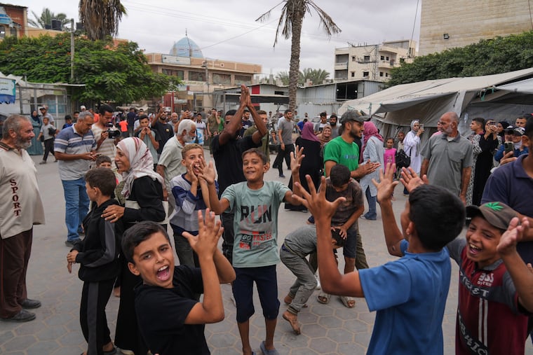 Palestinians celebrate following the announcement that Israel and Hamas have agreed to the first phase of a peace plan to pause the fighting in Gaza.
