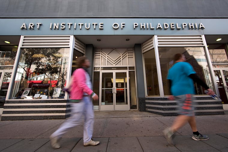 People walk past the Art Institute of Philadelphia operated by the Education Management Corporation on Nov. 16, 2015, in Philadelphia. The Biden administration on Wednesday said it will cancel $6 billion in student loans for people who attended the Art Institutes, a system of for-profit colleges that closed the last of its campuses in 2023 amid accusations of fraud. (AP Photo/Matt Rourke, File)