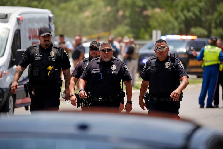 Police walk near Robb Elementary School after a shooting there in May left 19 students and two teachers dead.