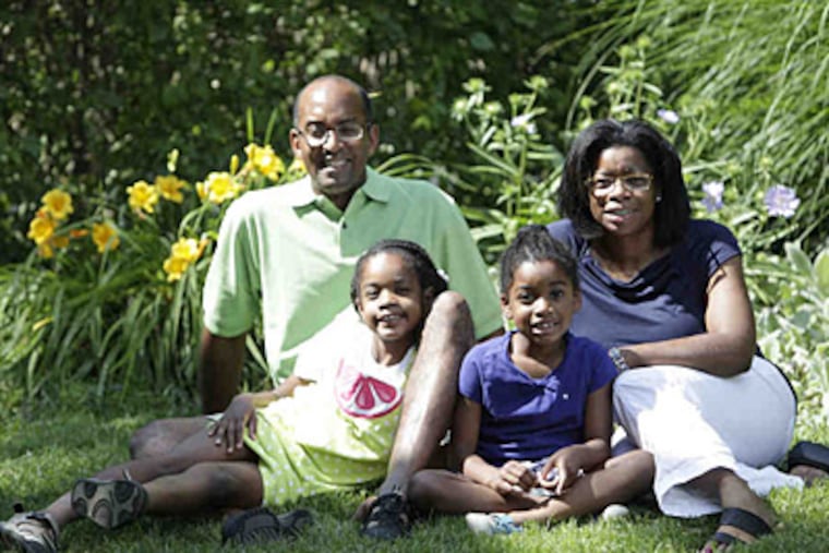 Relaxing outside their Wallingford home are Ernest and Miriam Wright and daughters Jillian (left), 7, and Lauren, 5. The family moved to the Delaware County suburb from Southwest Philadelphia during Miriam Wright's second pregnancy. (David Swanson/Staff)