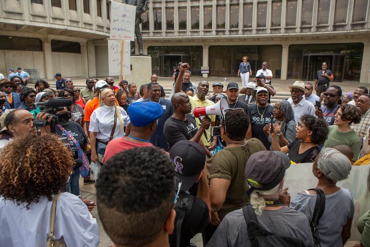 Solomon Jones speaks through a megaphone as a crowd of people gather outside of Philadelphia Police headquarters at 8th and race streets to protest the 330 active Philadelphia police officers included in a database of racist Facebook comments on Friday, June 07, 2019.