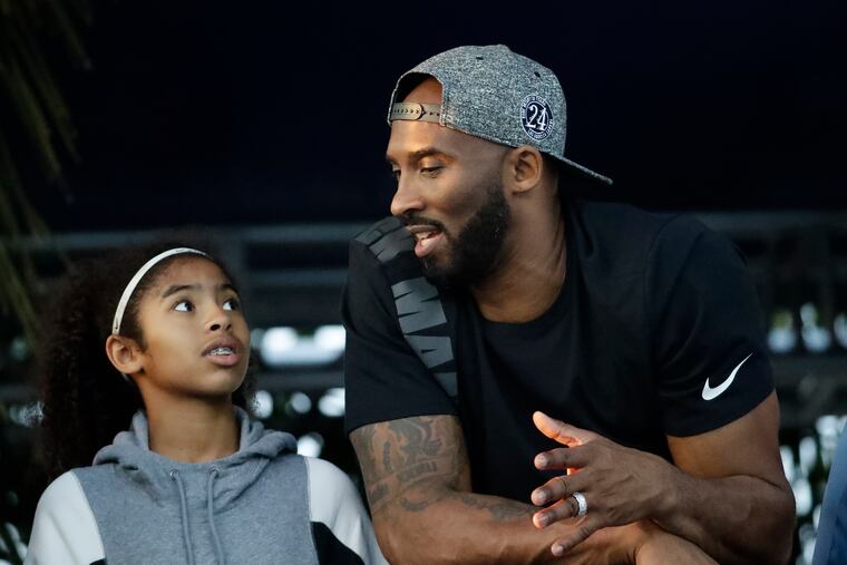 In this July 26, 2018 photo, former Los Angeles Laker Kobe Bryant and his daughter Gianna watch the U.S. national championships swimming meet in Irvine, Calif.