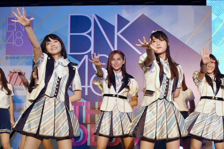 FILE - In this June 2, 2017, file photo, Thai pop band BNK 48 performs for the first time in a large commercial facility in Bangkok, Thailand. The popular Thai music act BNK 48 has set off a scandal after one of its members wore a shirt showing the swastika flag of Nazi Germany during a performance. (The Yomiuri Shimbun via AP Images)