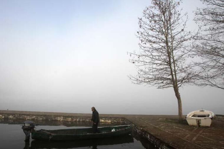 A man prepares to take his boat out into Lake Pamvotis amid heavy morning fog after going shopping in the northwestern Greek city of Ioannina, on Friday, March 1, 2013. Athens has overtaken the northwestern Epirus region as the area with the highest unemployment in Greece. The national jobless rate reached 27 percent in November, according to newly announced figures, led by greater Athens at 29 percent and followed by northwestern Greece at 28.2 percent. (AP Photo/Thanassis Stavrakis)