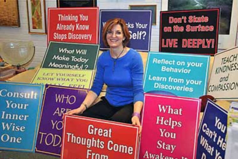 Meg Miller with some of her signs. A licensed psychologist, she intends to add 10 signs to her current collection of 40. (Sharon Gikoski-Kimmel / Staff Photographer)