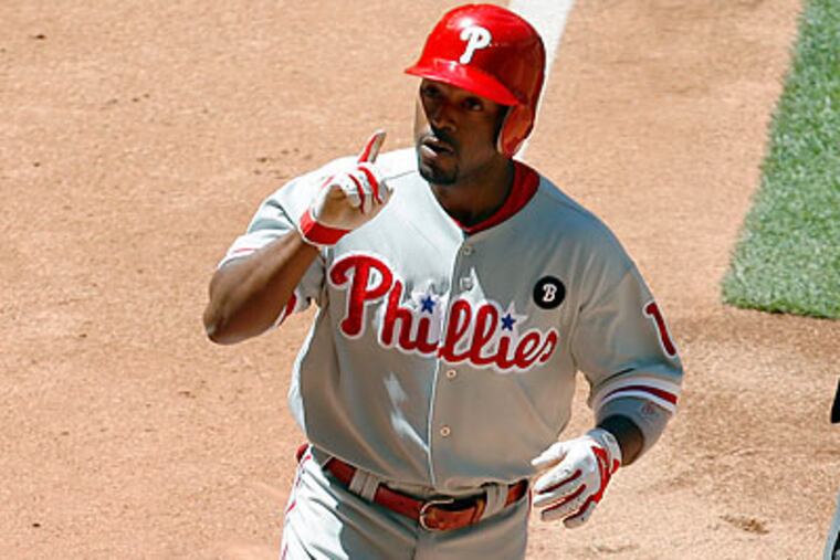 Jimmy Rollins celebrates after hitting one of the Phillies' three home runs against the Diamondbacks. (Ross D. Franklin/AP)