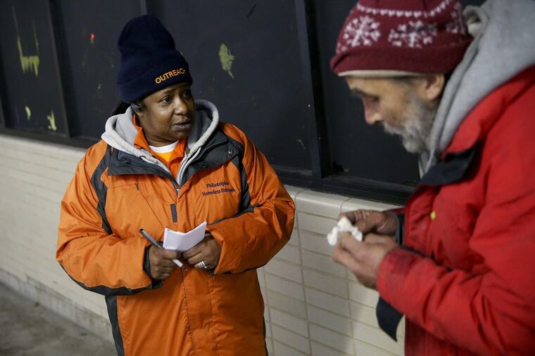 Project HOME outreach worker Michelle Sheppard, left, talks to a homeless man inside Suburban Station in Center City on Friday, Jan. 5, 2018. Sheppard, who herself was homeless for many years, now works to persuade homeless Philadelphians to seek shelter.