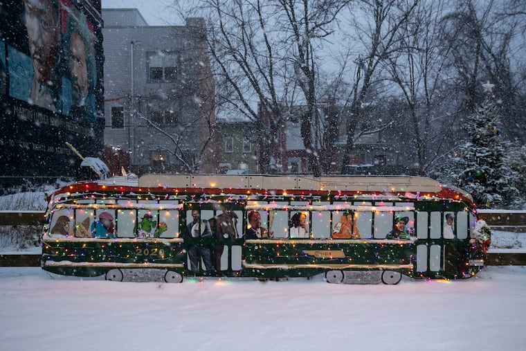 Snow falls on the Jolly Trolly at the Girard Dream Garden in Brewerytown during a pre-Christmas snowfall in 2020.