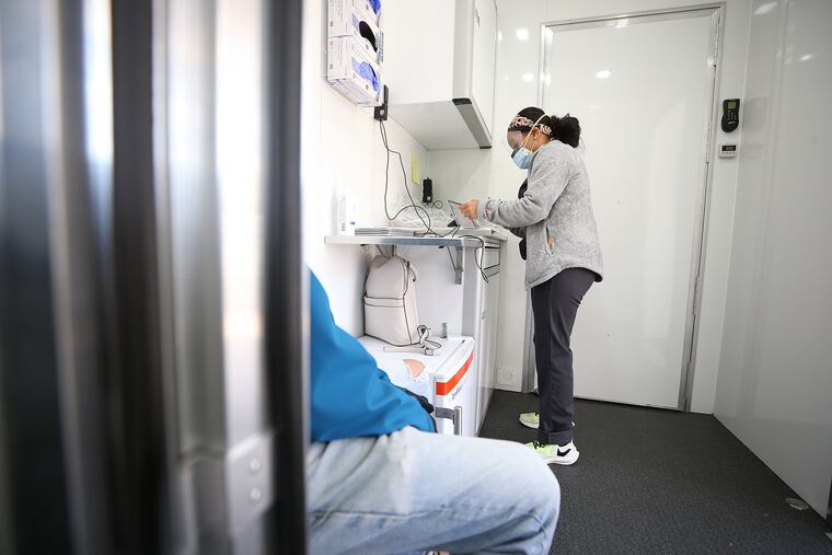 Medical assistant Jadirah Waliyuddin prepares to administer a COVID-19 test at the Vybe mobile testing lab in the parking lot of the Kensington Community Food Co-op in Philadelphia, Pa. on November 18, 2020.