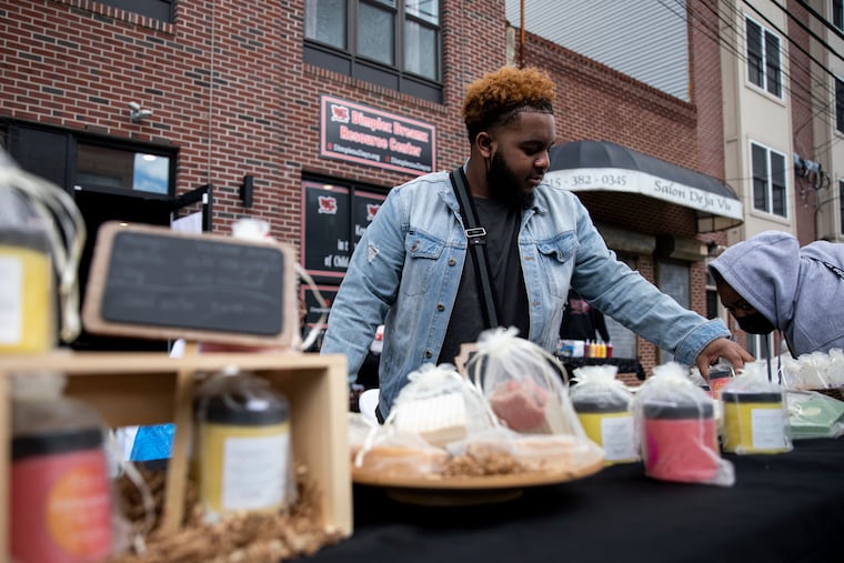 Elijah Barker, a senior at Science Leadership Academy Beeber High School, sets up a stand where he is selling skincare products in April 2022. Teaching that gives students real-world experiences may help reduce absenteeism, AJ Ernst writes.