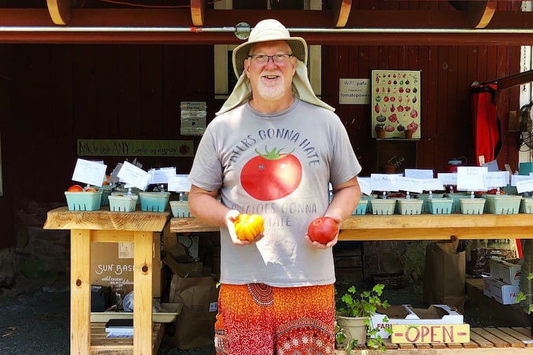 Farmer Dan Waber in front of the farm stand at his Rainbow Tomatoes Garden in East Greenville, Montgomery County, where he grows 320 varieties of heirloom tomatoes and also sells what he bills as the world's largest collection of tinned fish.