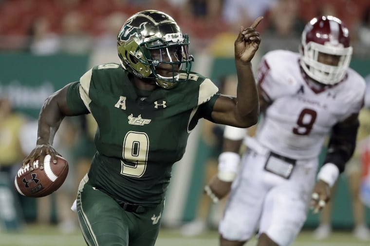 South Florida quarterback Quinton Flowers runs past Temple’s Jacob Martin during the second half Thursday.