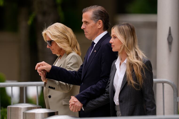 Hunter Biden, center, accompanied by his mother, first lady Jill Biden, left, and his wife, Melissa Cohen Biden, right, walks out of federal court on Tuesda.