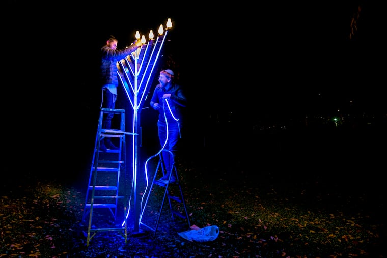 November 29, 2021: Rabbis (and brothers) with the Chabad Lubavitch Synagogue in Cherry Hill, Yakov Mangel (left) and Laizer Mangel set up the large Hanukkah menorah in Haddonfield's Library Point just before Thanksgiving. Chabad of Camden and Burlington Counties will host the borough's public lightning ceremonies Monday night at 6 with music, latkes, doughnuts, dreidels, and chocolate gelt.
