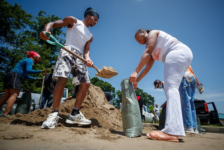 Christian Mosley-Richardson (left) helps Johnisha West fill sandbags Monday ahead of Tropical Storm Bertha at Morris FX Jeff Sr. Park in New Orleans.