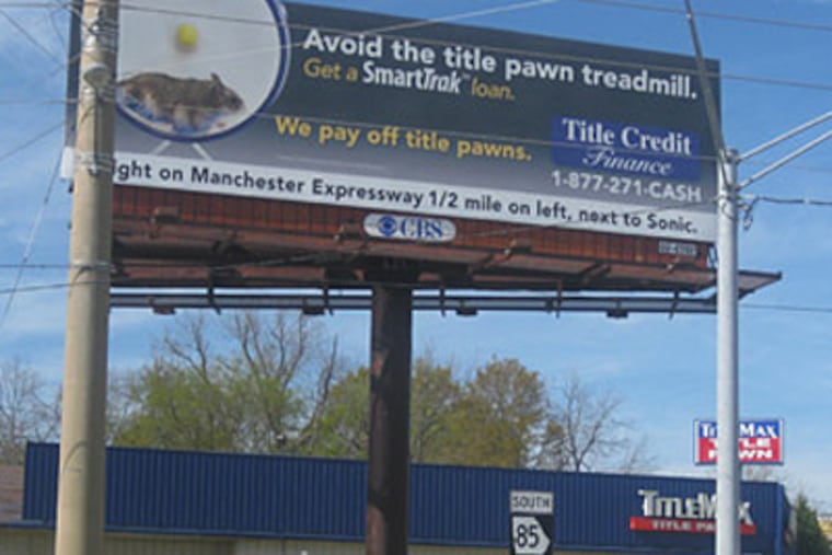 A billboard for Title Credit Finance above a TitleMax storefront shows a picture of a hamster on a wheel and urges borrowers to 'avoid the title pawn treadmill.' (Mitchell Hartman/Marketplace)