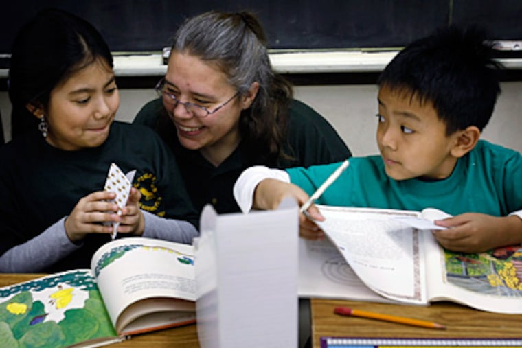 Finletter third-grade teacher Sherry Longstreth , with students Ashley Scott (left) and Phuc Son,is participating in a program begun by Children's Literacy Initiative, a Philadelphia nonprofit. (Michael S. Wirtz / Staff Photographer)