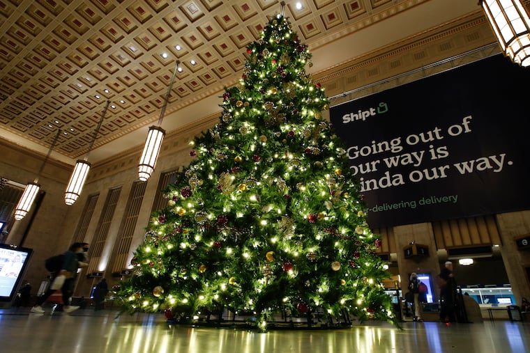 Travelers walk near the Christmas Tree at 30th Street Station.