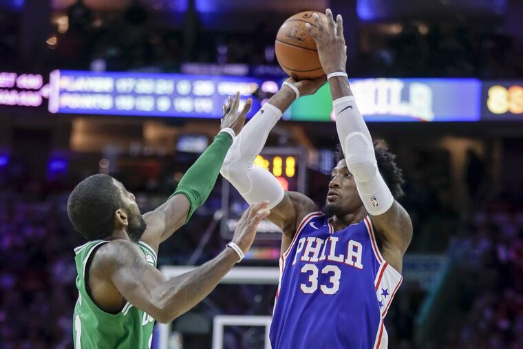 Sixers forward Robert Covington shoots the basketball over Boston Celtics guard Kyrie Irving on Friday, October 20, 2017 in Philadelphia. YONG KIM / Staff Photographer
