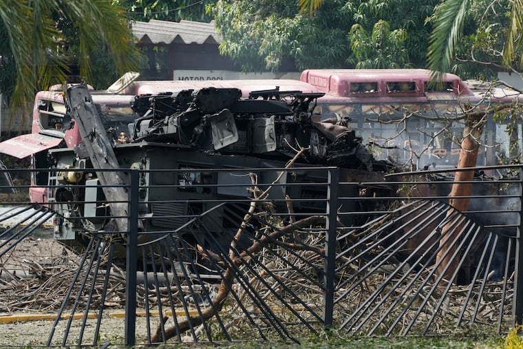 A destroyed armored vehicle sits at La Carlota airport in Caracas, Venezuela, Saturday after U.S. military officials removed President Nicolás Maduro and spirited him out of the country.