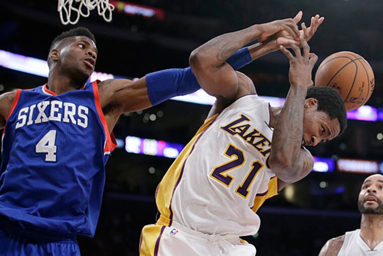 Los Angeles Lakers' Ed Davis, right, and Philadelphia 76ers' Nerlens Noel fight for a rebound during the second half of an NBA basketball game, Sunday, March 22, 2015, in Los Angeles. The Lakers 101-87. (Jae C. Hong/AP)