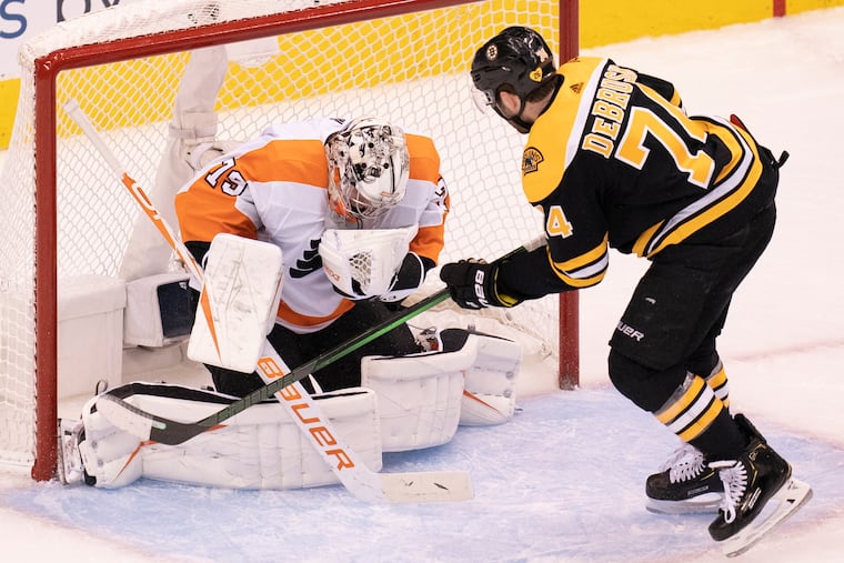Flyers goaltender Carter Hart (79) makes a save against Boston Bruins left wing Jake DeBrusk (74) during the first period.