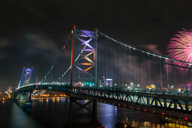 Fireworks over the Delaware River are viewed from the rooftop deck at the One Water Street apartment building in Philadelphia and framed by the Benjamin Franklin Bridge on New Year's Eve.