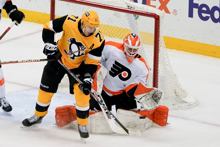 Flyers goaltender Brian Elliott makes a save as the Pittsburgh Penguins' Evgeni Malkin looks for a rebound during the first period Thursday.