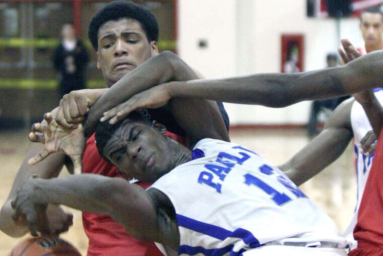 Paul VI's Roosevelt Cubbage is bent over backward as the ball pops free during a scramble for a second-half rebound. Behind him is Paulsboro defender Julien Davenport.