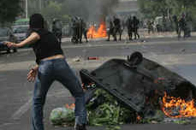 Smoke rises from a burning barricade as supporters of opposition leader Mir Hossein Mousavi throw stones at police in Tehran, Iran. Security forces usedtear gas, water cannons, and batons on demonstrators protesting the reelection of President Mahmoud Ahmadinejad. President Obama urged Iran's government "to stop all violent and unjust actions against its own people." Story on A3.