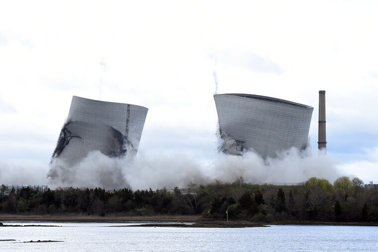 The two 500-foot cooling towers of the former Brayton Point Station collapse after explosive charges are detonated in Somerset, Mass., on April 27, 2019. The plant had burned coal since 1963. A trash burning plant in Martinsburg, West Va., aims to be part of the future.
