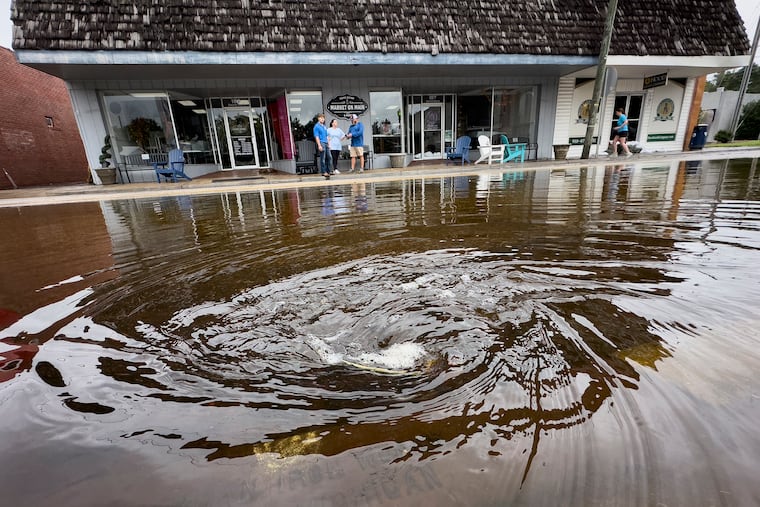 A drain pulls in residual rainwater amid flooding in downtown Bladenboro, N.C., on Thursday during Tropical Storm Debby. Debby-related effects are expected all along the Eastern seaboard.
