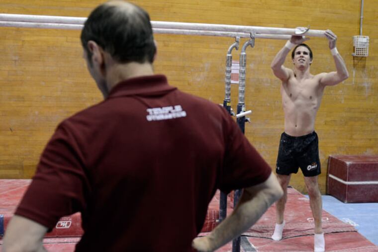 Hall of Fame Temple University men's gymnastics coach Fred Turoff
(left) helps student coach Alex Tighe work out December 6, 2013. In a
stunning move, Temple killed seven of its 24 intercollegiate sports
programs including men's gymnastics. Tighe exhausted his four years of
eligibility, and is finishing up his studies under a scholarship, while working out for competitions and helping to coach the team. (Tom Gralish/Staff Photographer)