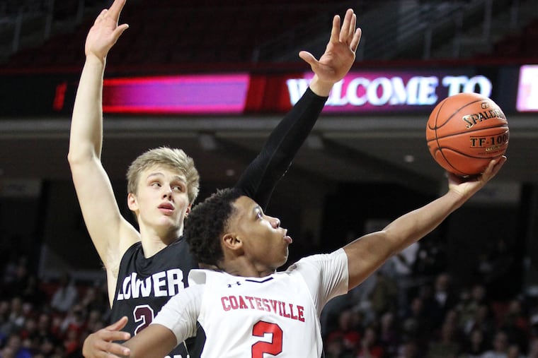 Jhamir Brickus, front, of Coatesville scores in front of Jack Forrest of Lower Merion in PIAA District 1 boys basketball semifinals at the Liacouras Center on Feb. 26, 2019.