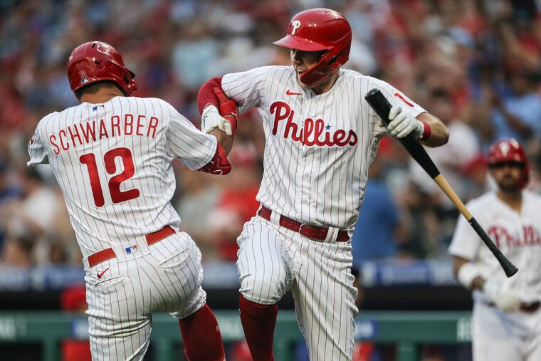 Kyle Schwarber celebrates with teammate Rhys Hoskins after his second home run of the game against the Nationals in the third inning Tuesday. The Phillies won, 11-0.