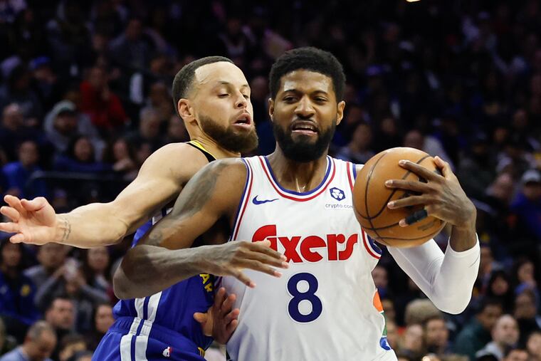 Sixers forward Paul George fights for the ball with Warriors star Stephen Curry on Saturday.
