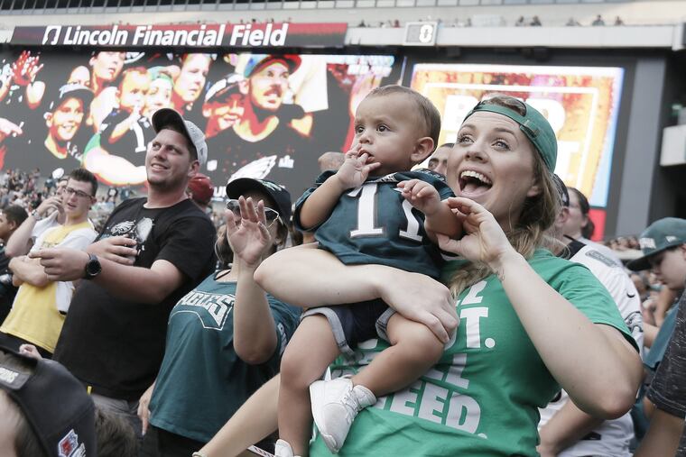 Eagles fan Kaitlyn Rivas screams as she realizes she and her 1-year-old son C.J. Rivas are being broadcast on the stadiums big screen during the open Eagles practice at Lincoln Financial Field in Phila., Pa. on Aug. 5, 2018.