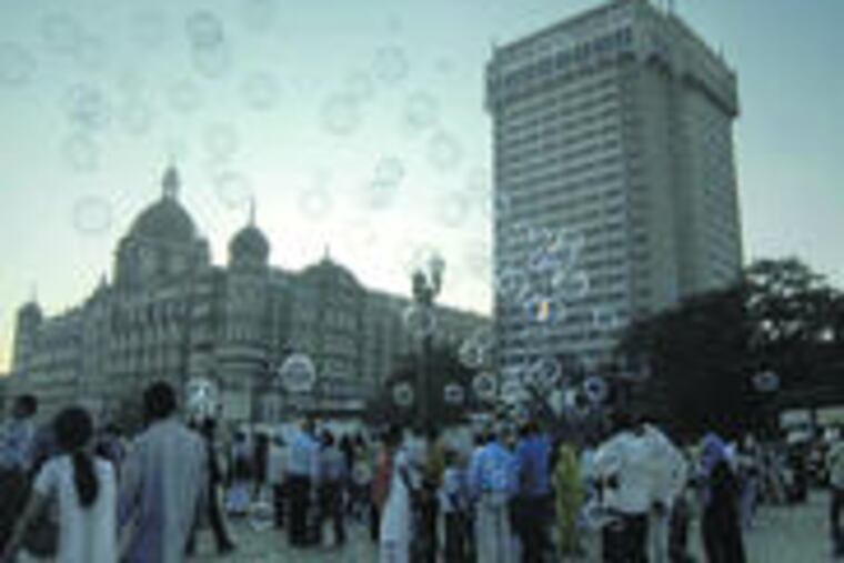 Soap bubbles lent a happier air in front of Mumbai's Taj Mahal hotel, one of the sites attacked last month. Managers said the Taj and Oberoi hotels would partly reopen this weekend.