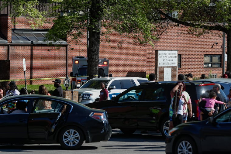 People gather outside Austin East High School in Knoxville, Tenn., as Knoxville police work the scene following a shooting at the school.