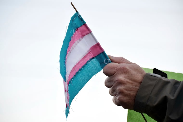 A person holds a transgender flag to show their support for the transgender community during a Transgender Day of Remembrance at Maryville College in 2016.