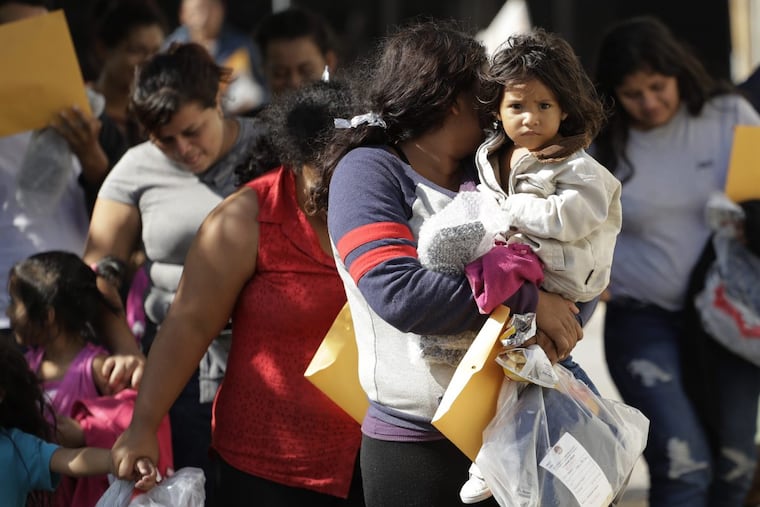 Immigrant families walk to a respite center after they were processed and released by U.S. Customs and Border Protection, Wednesday, June 27, 2018, in McAllen, Texas.