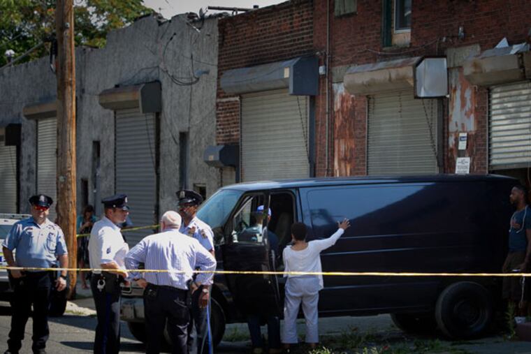 Philadelphia police were called to a small warehouse on 2600 block of
W. Hagert Street in the Strawberry Mansion section of the city on Tuesday, Aug. 25, 2015. The van in background was brought in to remove bodies discovered inside a warehouse. (ALEJANDRO A. ALVAREZ / Staff Photographer)