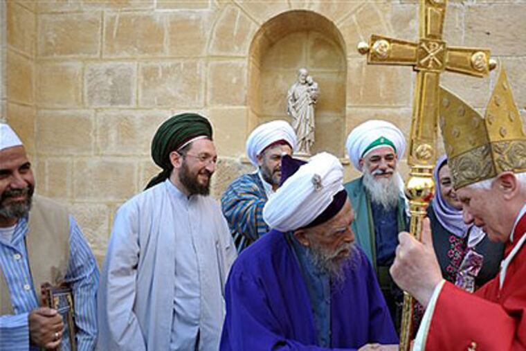 Sufi mystic Sheikh Nazim, next to other Muslim clergymen, shakes hands with Pope Benedict XVI before the mass led by the pontiff at the church of the Holy Cross at the compound of the Franciscan convent of Holy Cross, in Nicosia, Cyprus, last Saturday. (AP Photo / Osservatorio Romano, HO)